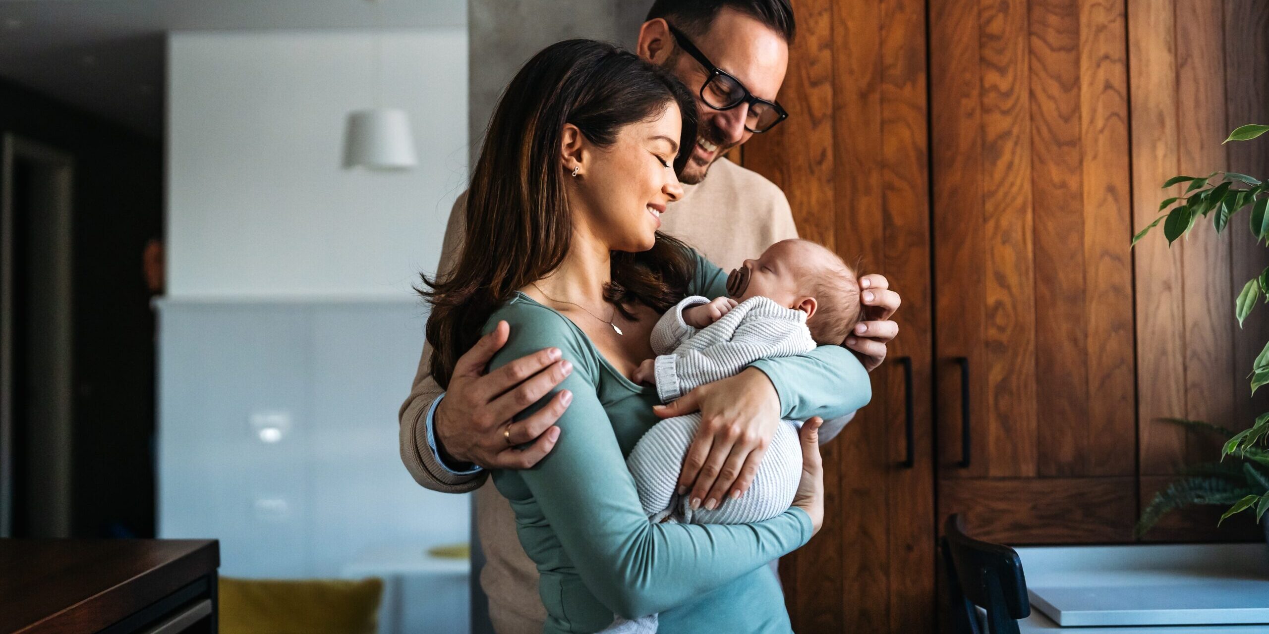 Young parents with baby consider insurance options.